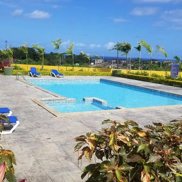 Community swimming pool with ocean views and blue loungers